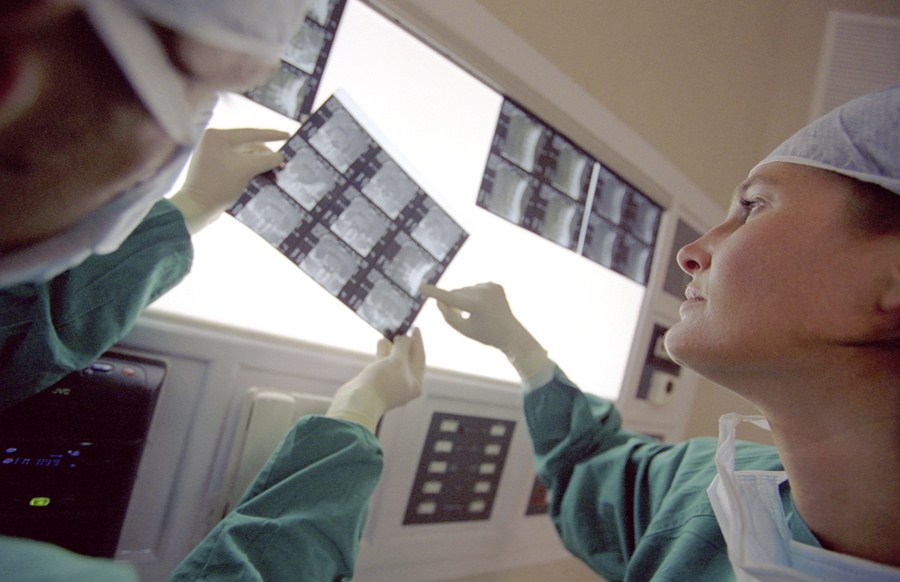 Profissionais de saúde olham exames de raio-x