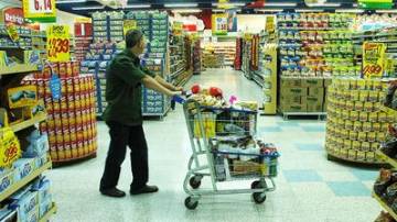 Homem com carrinho de supermercado entre as prateleiras de alimentos