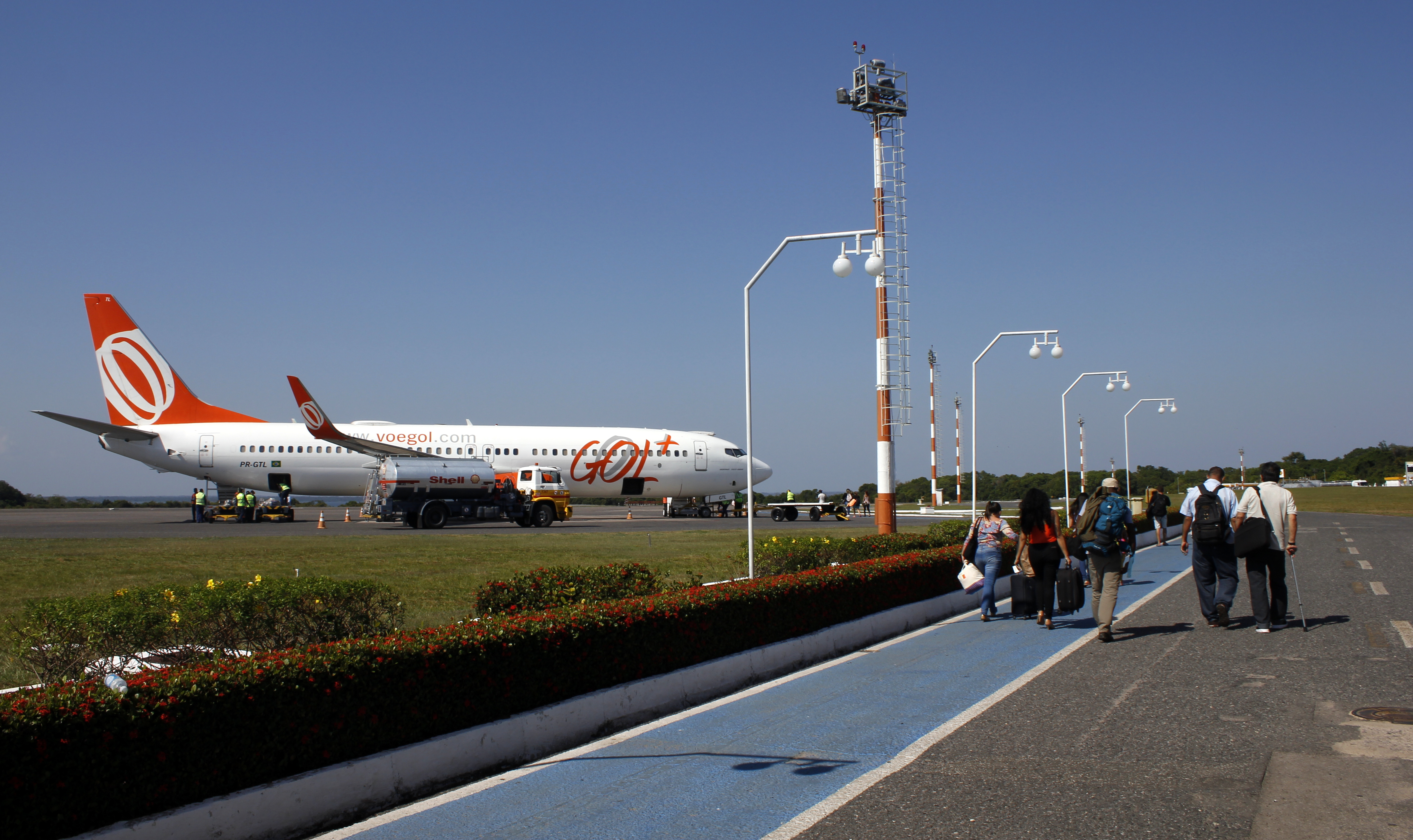 Avião da Gol com pessoas na pista a caminho da aereonave