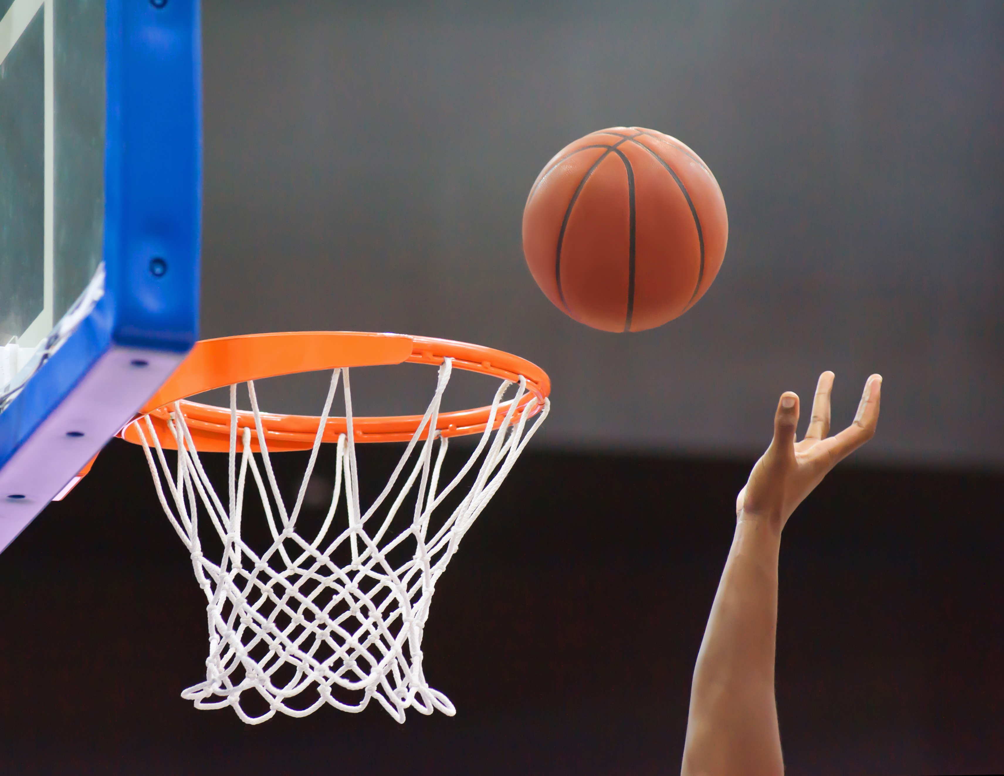 Bola sendo arremessada na cesta de basquete