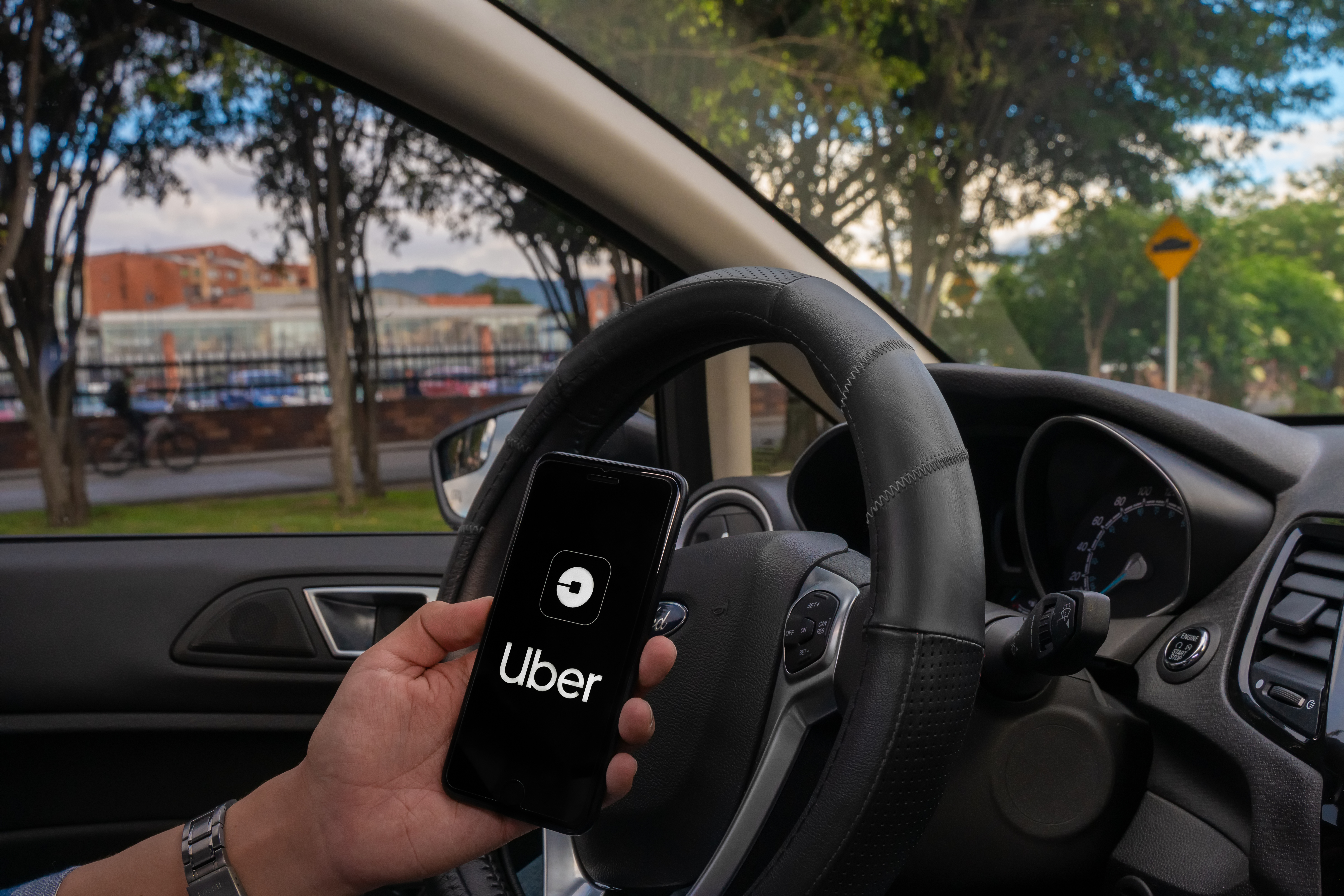 Homem segurando celular com o aplicativo do Uber