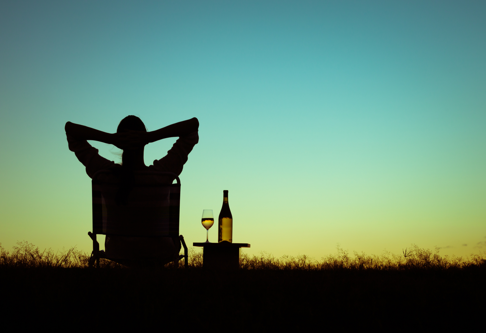 Homem relaxando tomando vinho no por do sol