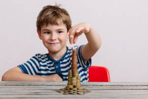 Criança fazendo uma pilha de moedas