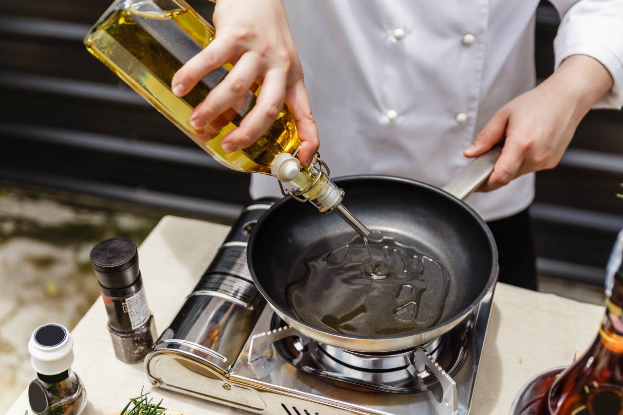 Chefe cozinhando com azeite de oliva