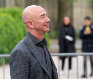 Jeff Bezos, CEO da Amazon, vestindo terno cinza, olhando para o lado direito
