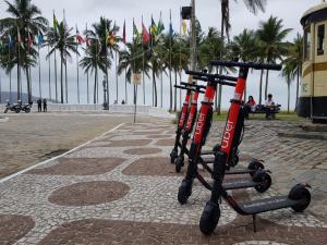 Fila de patinetes elétricos da Uber estacionados no calçadão da praia de Santos, no litoral paulista