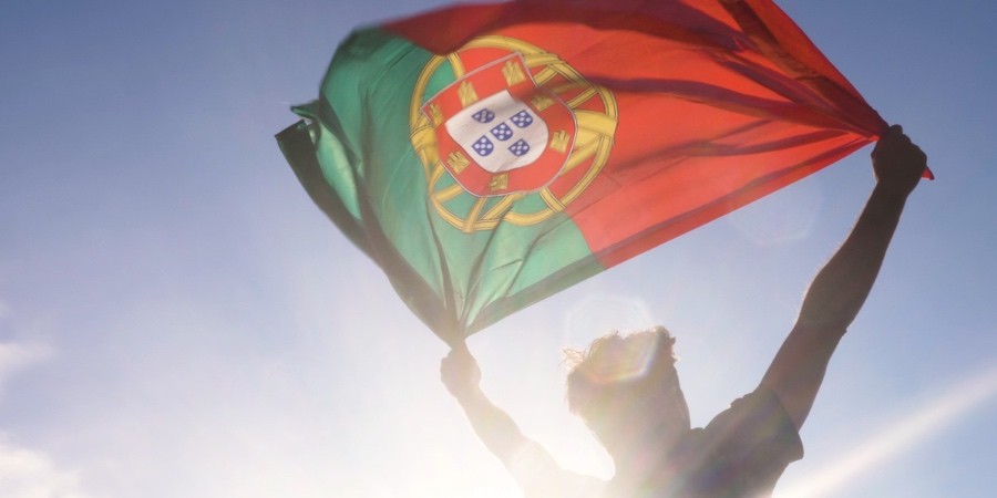 Homem segura bandeira de Portugal contra a luz