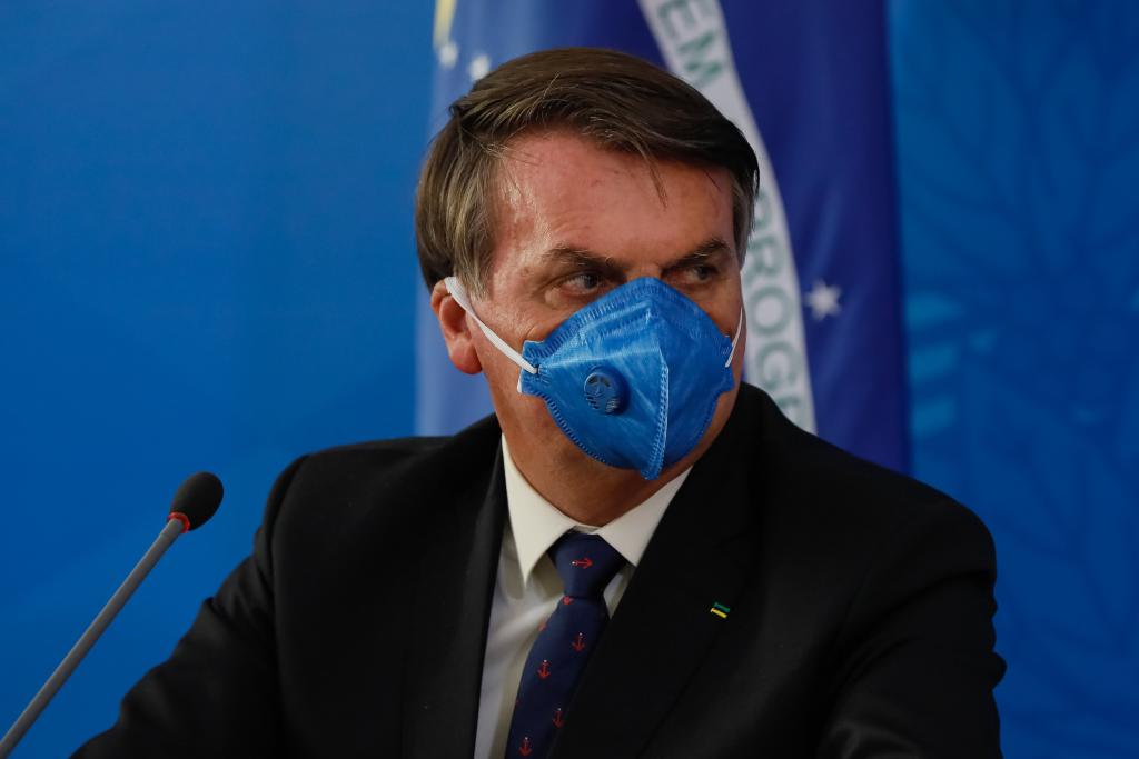 Jair Bolsonaro participa de entrevista à imprensa usando uma máscara de proteção