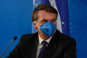 Jair Bolsonaro participa de entrevista à imprensa usando uma máscara de proteção