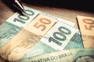 Brazilian currency. Money on the wooden table in one hundred and fifty reais banknotes.