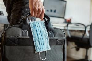 man with a briefcase and a surgical mask
