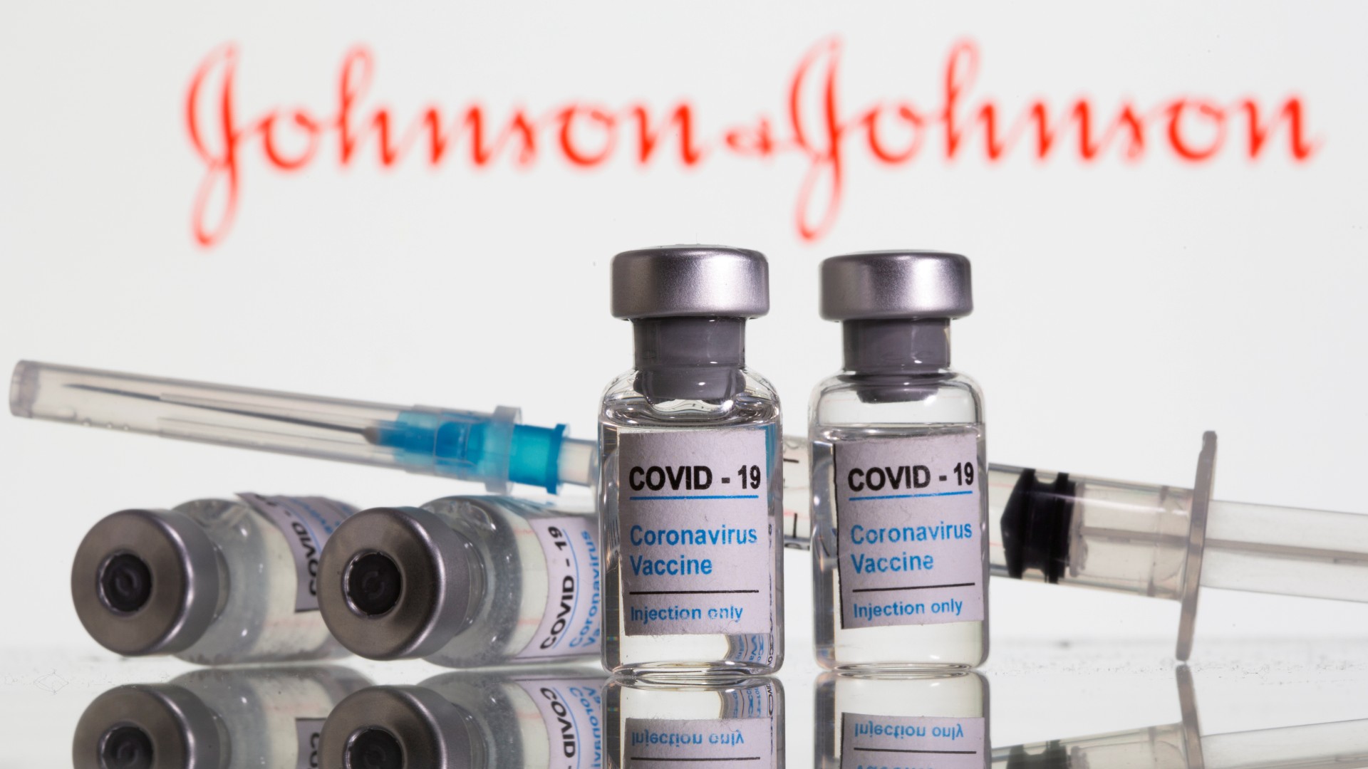 Frascos rotulados como de vacina contra Covid-19 em frente ao logo da Johnson and Johnson em foto de ilustração 09/02/2021 REUTERS/Dado Ruvic