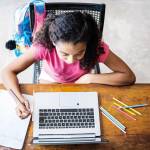 Menina estudando com laptop em casa
