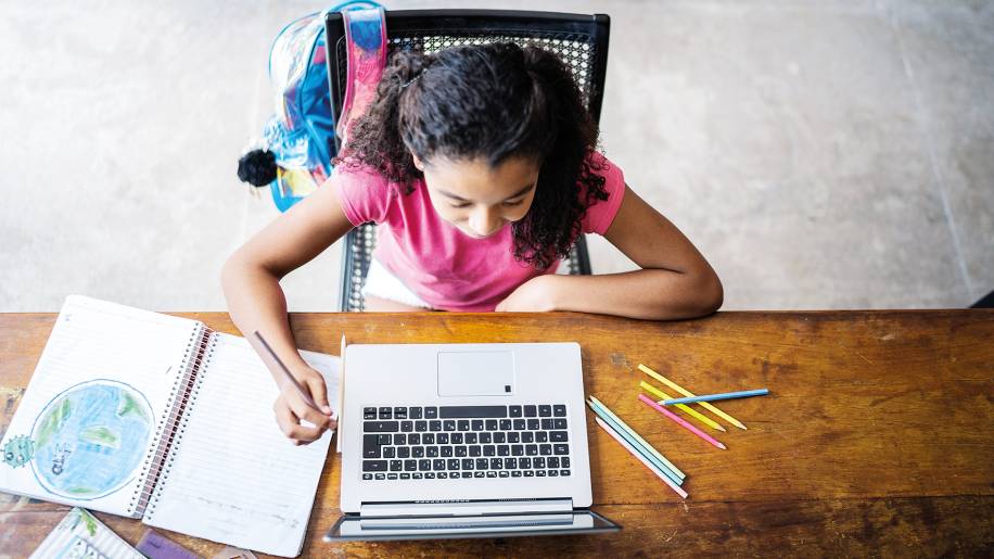 Menina estudando com laptop em casa