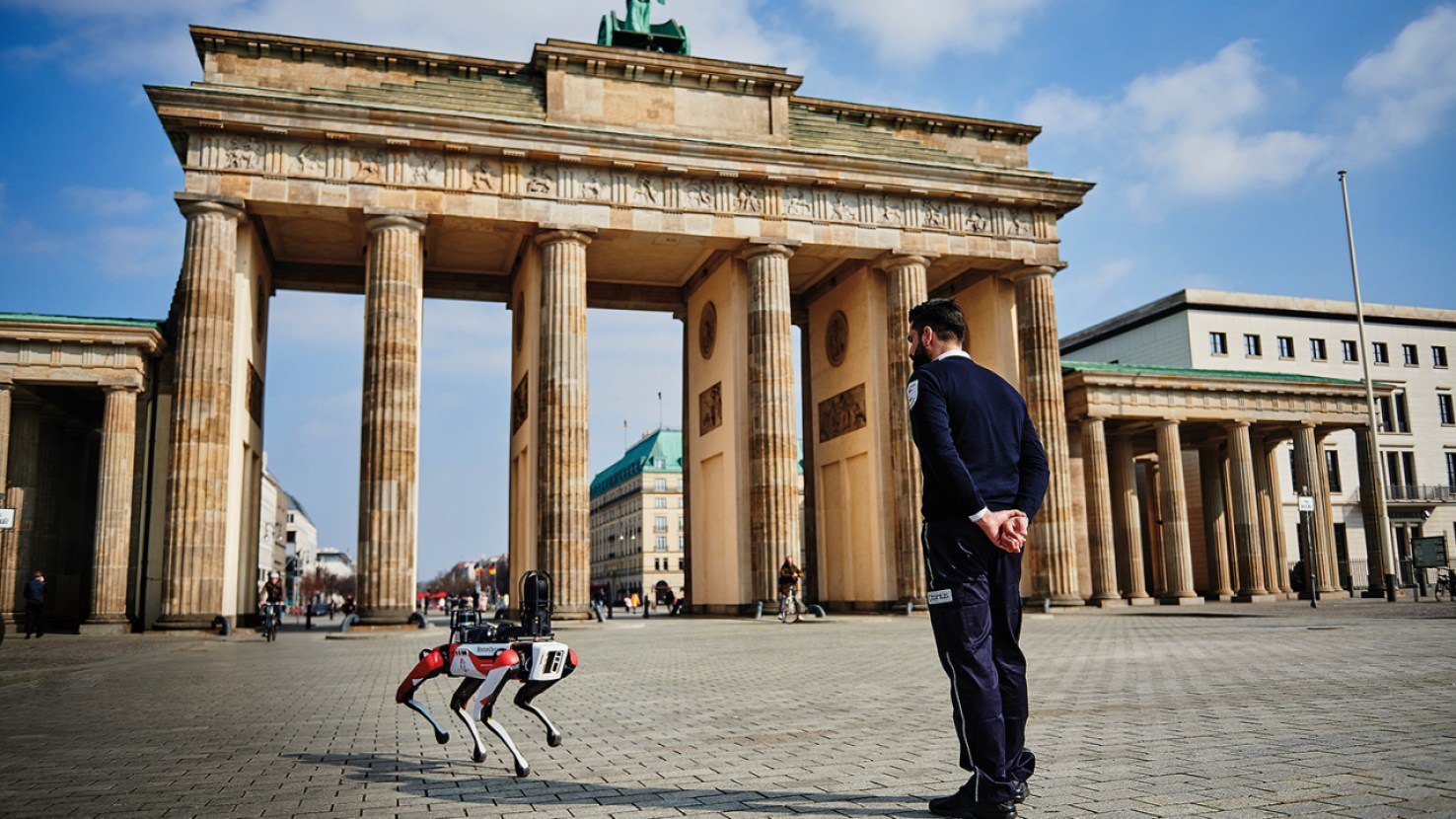 Cão-robô junto de um profissional da segurança trabalhando juntos na Alemanha