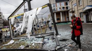 KIEV, UCRÂNIA - 24 de FEVEREIRO: Pessoas ao redor de uma esturutra danificada por um foguete em 24 de fevereiro de 2022 em Kiev, Ucrânia (Chris McGrath/Getty Images)