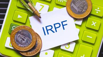 Foto de stock de As iniciais IRPF escritas na cor azul em um pequeno pedaço de papel. Caneta e Calculadora em composição. Economia brasileira, imposto de renda.