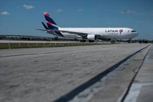 Avião de carga da Latam taxiando em pista de pouso no aeroporto