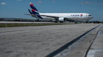Avião de carga da Latam taxiando em pista de pouso no aeroporto