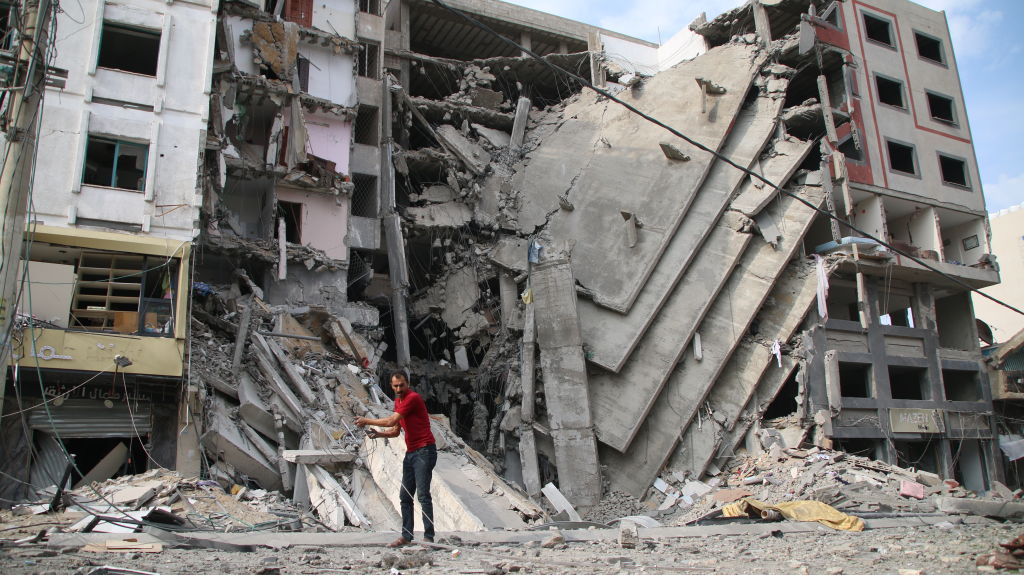 Cidadãos palestinos inspecionam danos às suas casas causados por ataques aéreos israelenses em 9 de outubro de 2023 em Gaza. Quase 500 pessoas morreram em Gaza depois que Israel lançou ataques aéreos retaliatórios após o ataque de sábado (7) pelo Hamas (Ahmad Hasaballah/Getty Images)