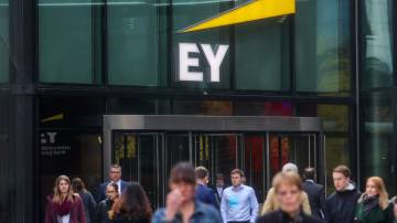 Pedestres passam em frente ao escritório da Ernst & Young em Londres (Simon Dawson/Bloomberg)