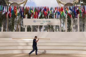 Um trabalhador passa por um degrau para a foto de grupo de chefes de estado antes da cerimônia de abertura da Conferência Climática COP28 da UNFCCC na Expo City Dubai em 30 de novembro de 2023 em Dubai, Emirados Árabes Unidos