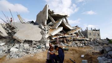 Crianças palestinas ficam perto do local de um ataque israelense a uma casa, em Rafah (REUTERS/Mohammed Salem)