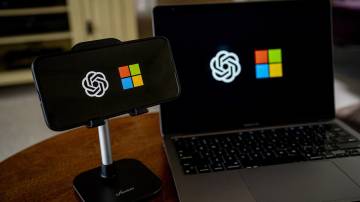 Os logotipos da OpenAI e da Microsoft em um smartphone e laptop (David Paul Morris/Bloomberg)