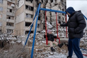 Adulto e criança em meio aos destroços de guerra na Ucrânia. Foto: Reprodução/UNICEF
