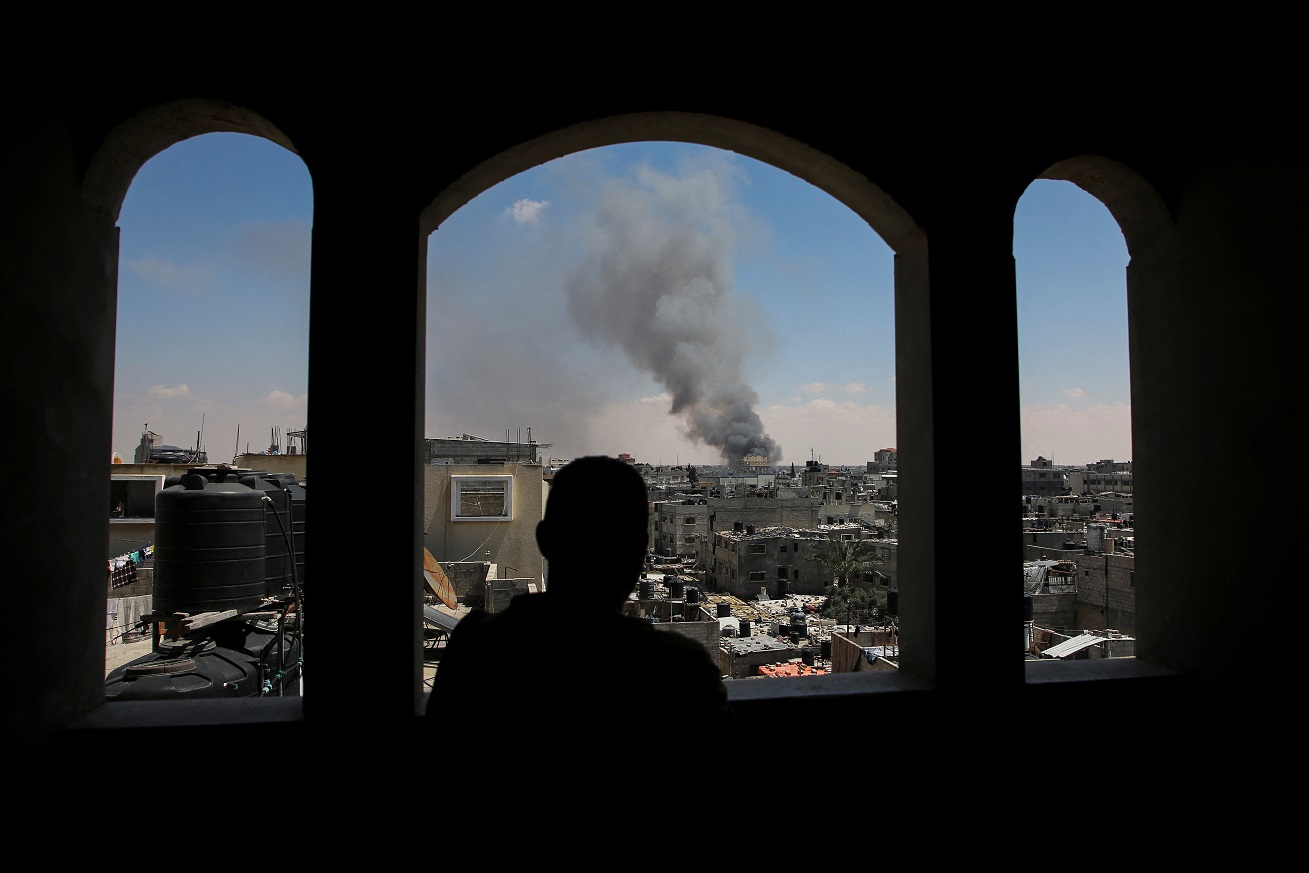 Homem palestino observa fumaça após ataques de forças de Israel a Rafah, na Faixa de Gaza (REUTERS/Hatem Khaled)