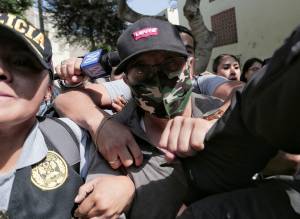 Policiais escoltam Nicanor Boluarte, irmão da presidente peruana Dina Boluarte, enquanto ele sai de casa. Foto: REUTERS/Gerardo Marin