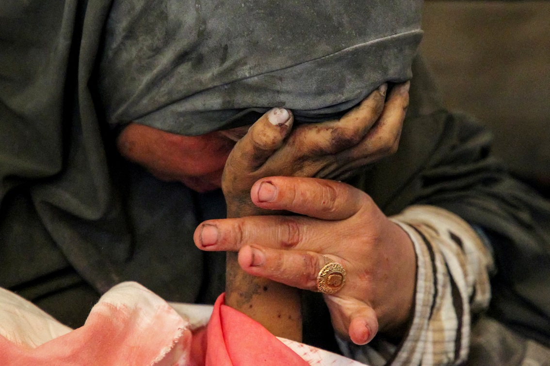 Mulher palestina segura a mão de seu filho Hazma, morto em um ataque israelense em Rafah, no sul da Faixa de Gaza. 09/05/2024 REUTERS/Hatem Khaled