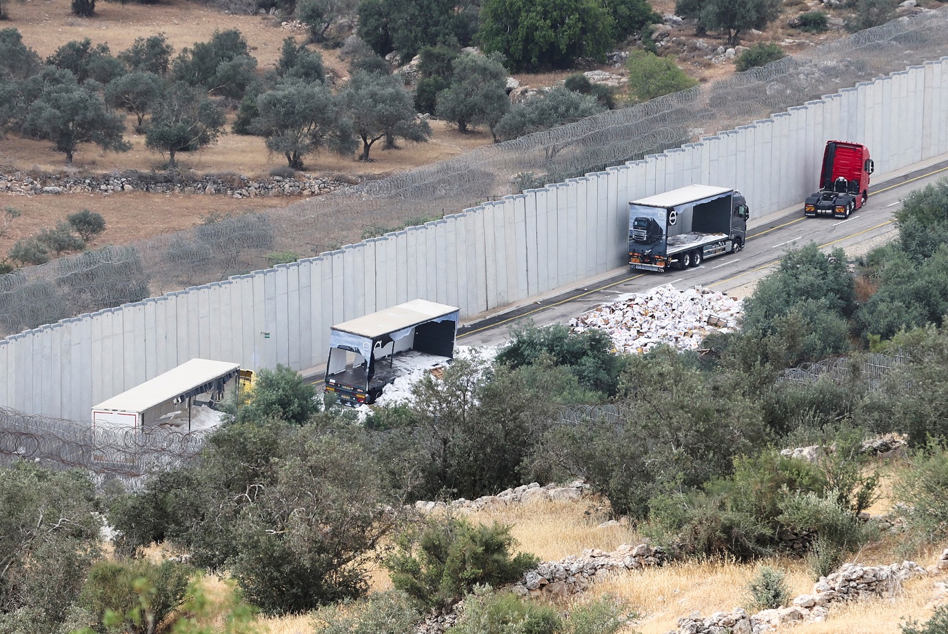 Imagem de caminhões que transportavam ajuda para Gaza após serem danificados por colonos israelenses perto de posto de controle próximo a Hebron, na Cisjordânia ocupada por Israel (REUTERS/Mussa Qawasma)