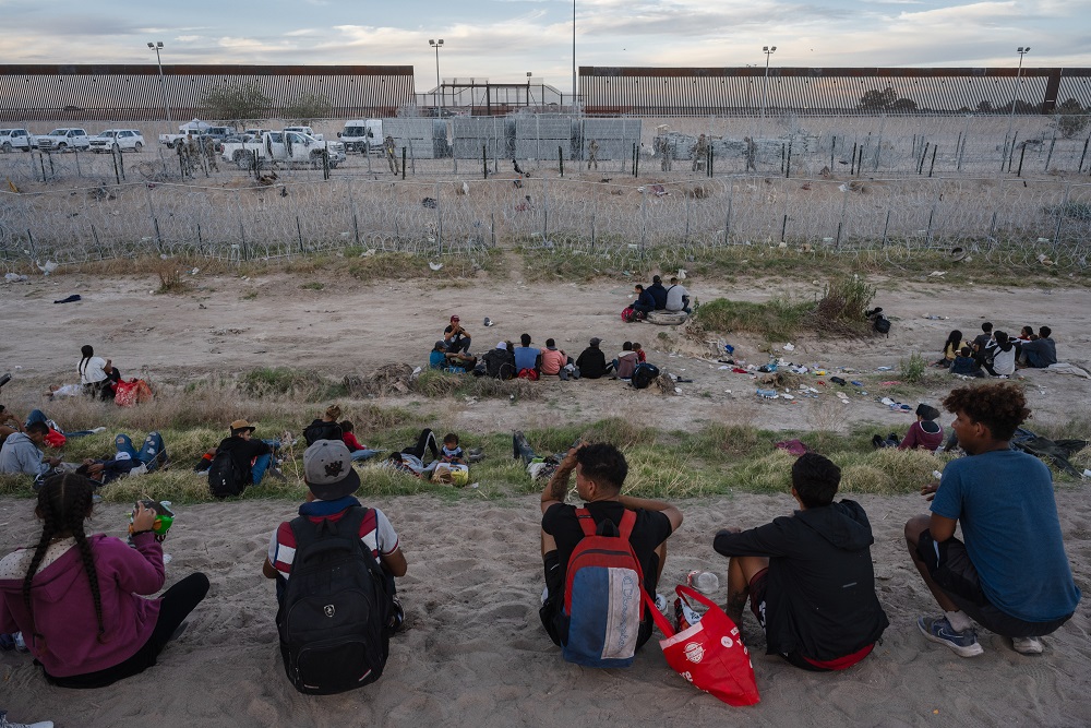 Migrantes descansam às margens do Rio Grande, na fronteira entre EUA e México, em Ciudad Juarez (Justin Hamel/Bloomberg)