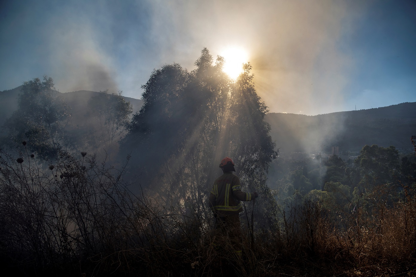 Um bombeiro israelense trabalha acompanhando o lançamento de foguetes fronteiriços do Líbano para Israel, em meio às contínuas hostilidades transfronteiriças entre o Hezbollah e as forças israelenses, nos arredores de Kiryat Shmona, no norte de Israel, em 2 de julho de 2024. REUTERS/Gil Eliyahu
