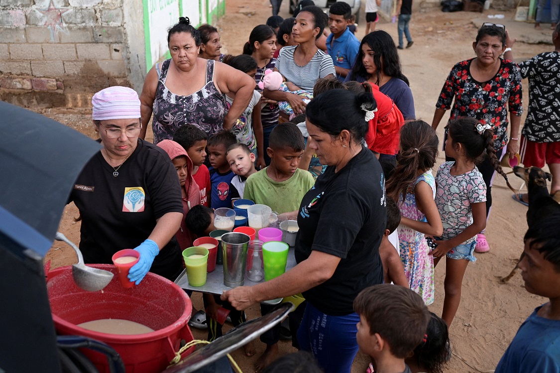 Pessoas recebem alimentos de Carolina Leal, diretora e fundadora da fundação Alimentando Suenos, em Maracaibo, Venezuela, em 12 de junho de 2024 REUTERS/Gaby Oraa