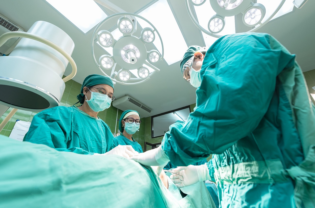 Equipe médica com três profissionais realiza cirurgia em hospital