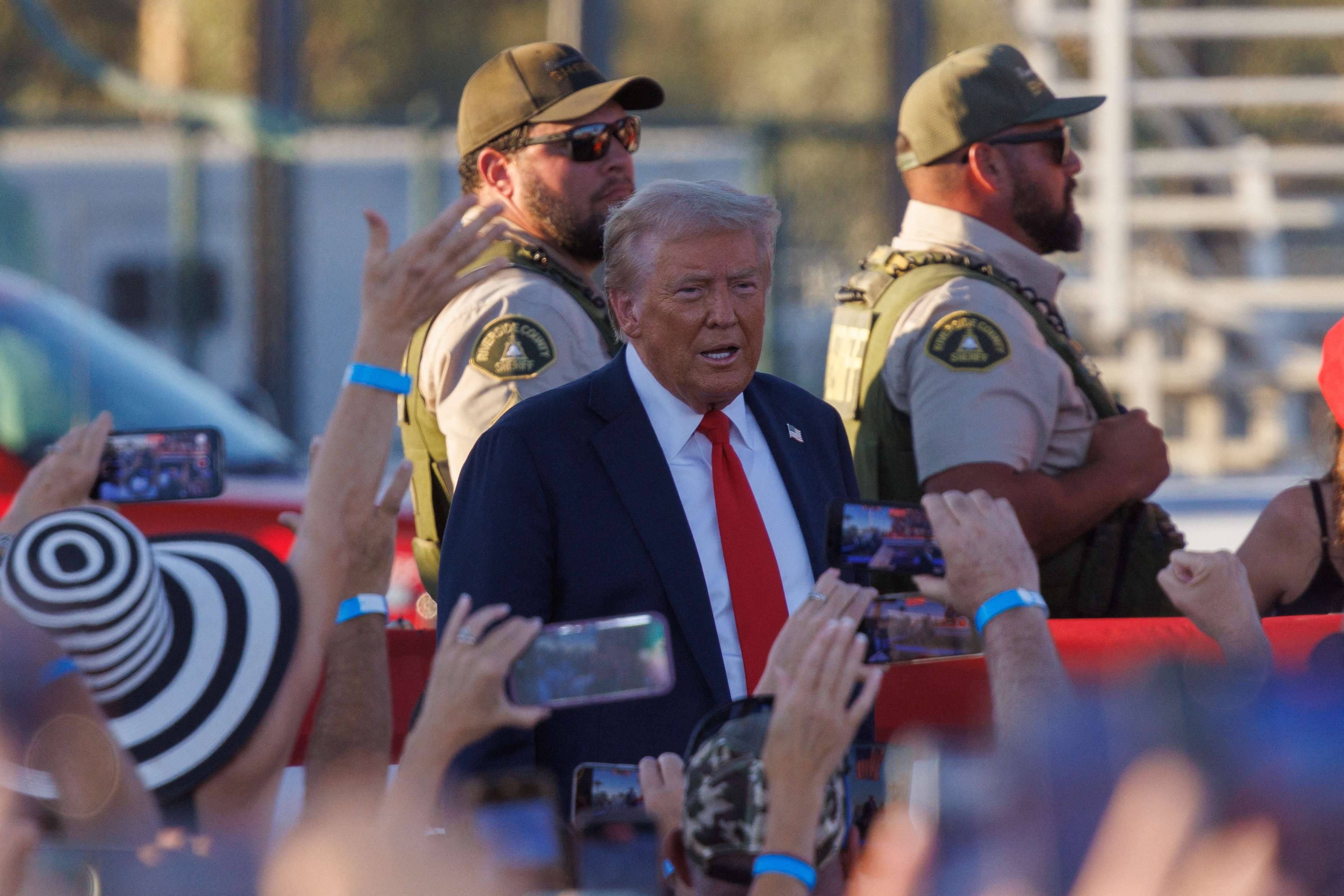 Oficiais do Condado de Riverside montam guarda enquanto o candidato presidencial Donald Trump fala em comício em Coachella, Califórnia, EUA, 12/10/2024 (Foto: Mike Blake/Reuters)