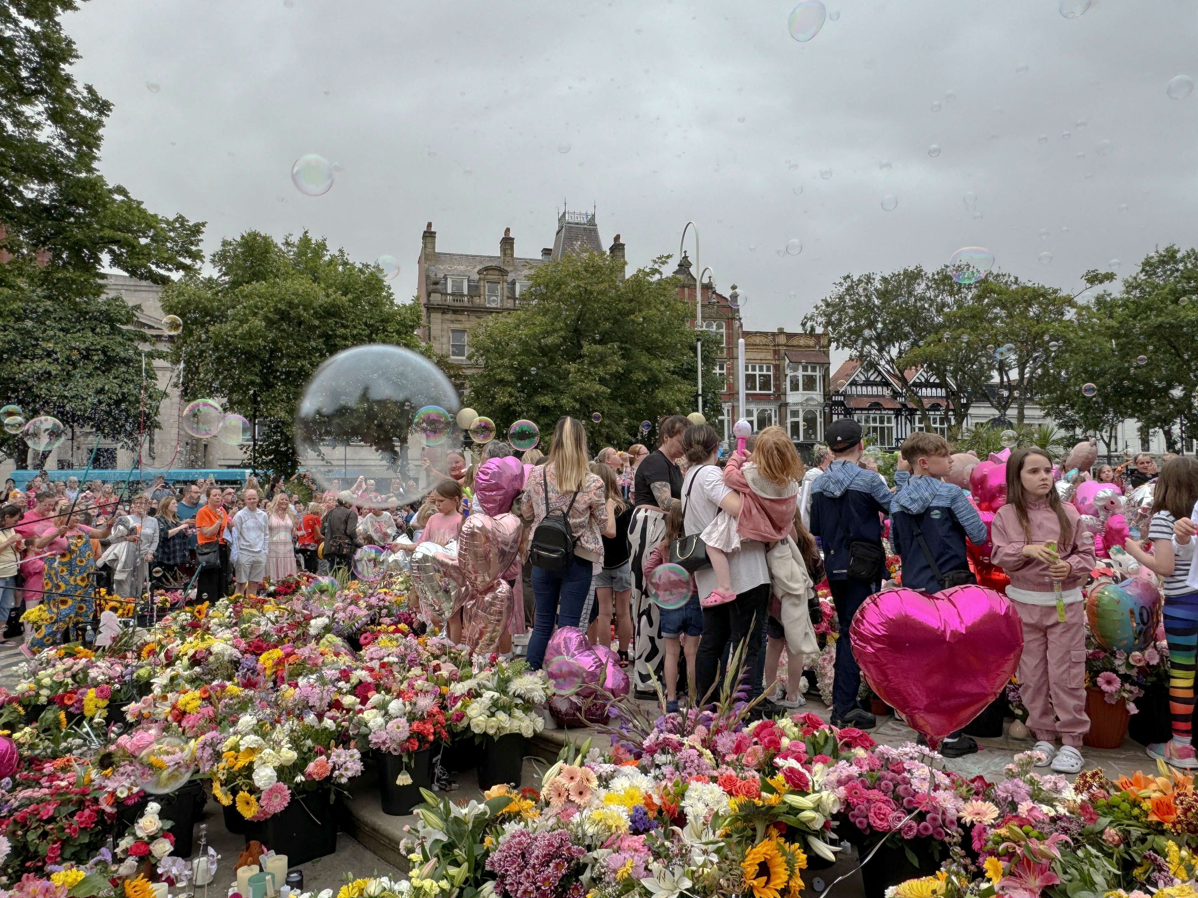 Pessoas sopram bolhas em homenagem às vítimas de ataque com faca em Southport - 5/08/2024 (Foto: Kirsten Donovan/Reuters)