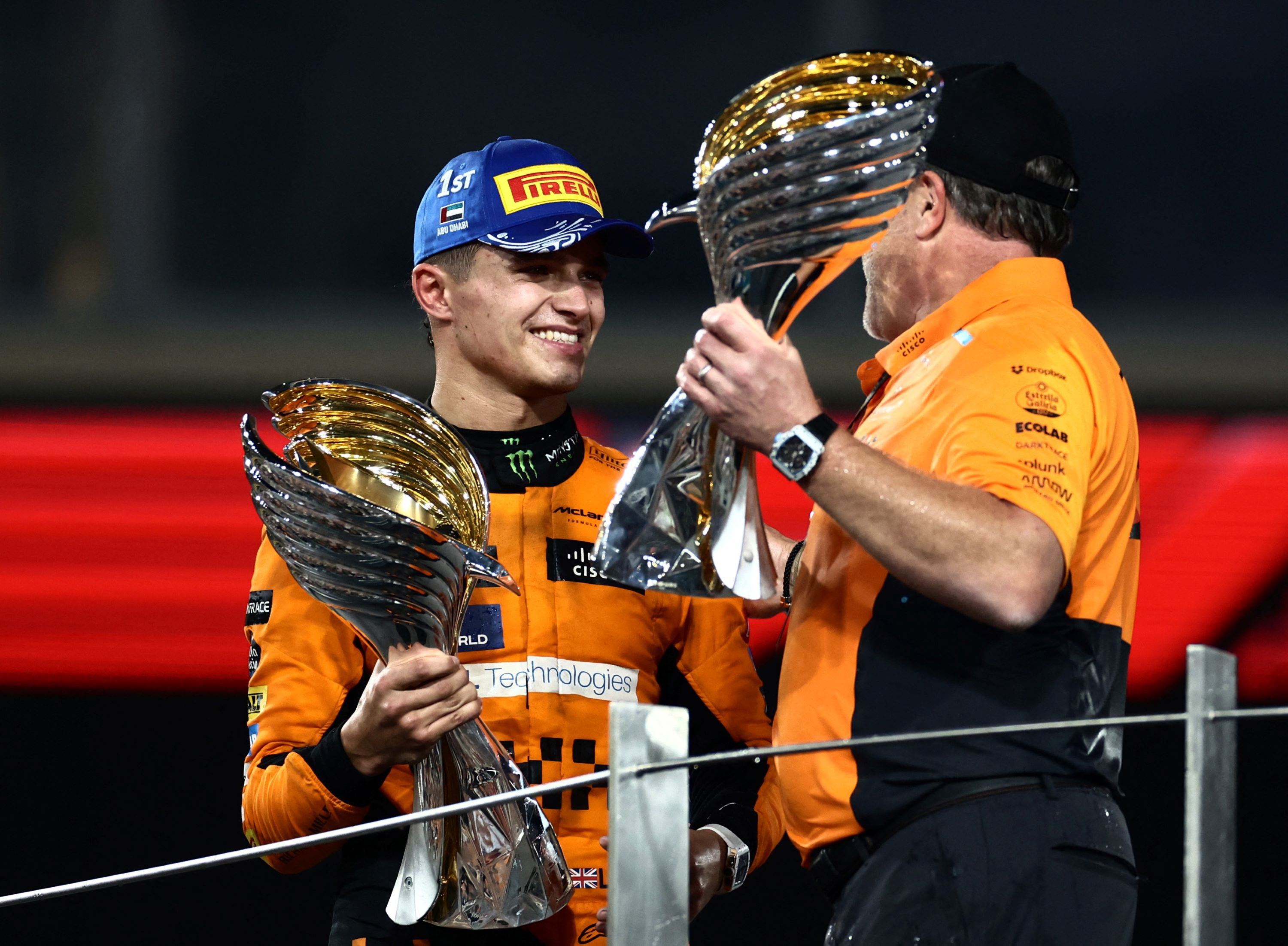 Formula One F1 - Abu Dhabi Grand Prix - Yas Marina Circuit, Abu Dhabi, United Arab Emirates - December 8, 2024 McLaren's Lando Norris celebrates on the podium with a trophy after winning the Abu Dhabi Grand Prix with McLaren chief executive Zak Brown REUTERS/Amr Alfiky
