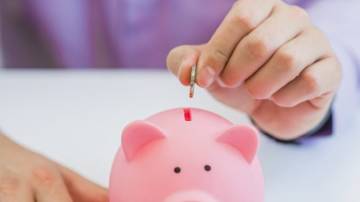 Saving money in piggy bank, close up