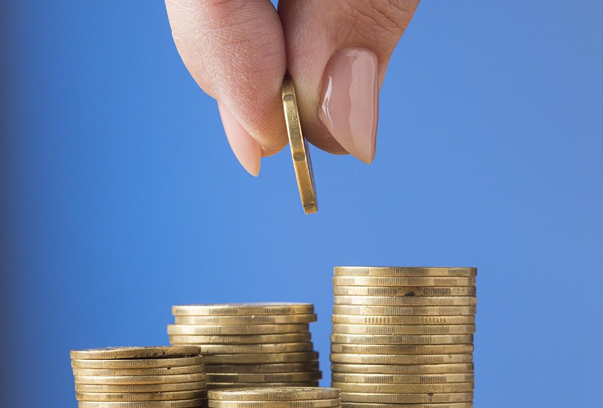 person-placing-coin-pile-coins