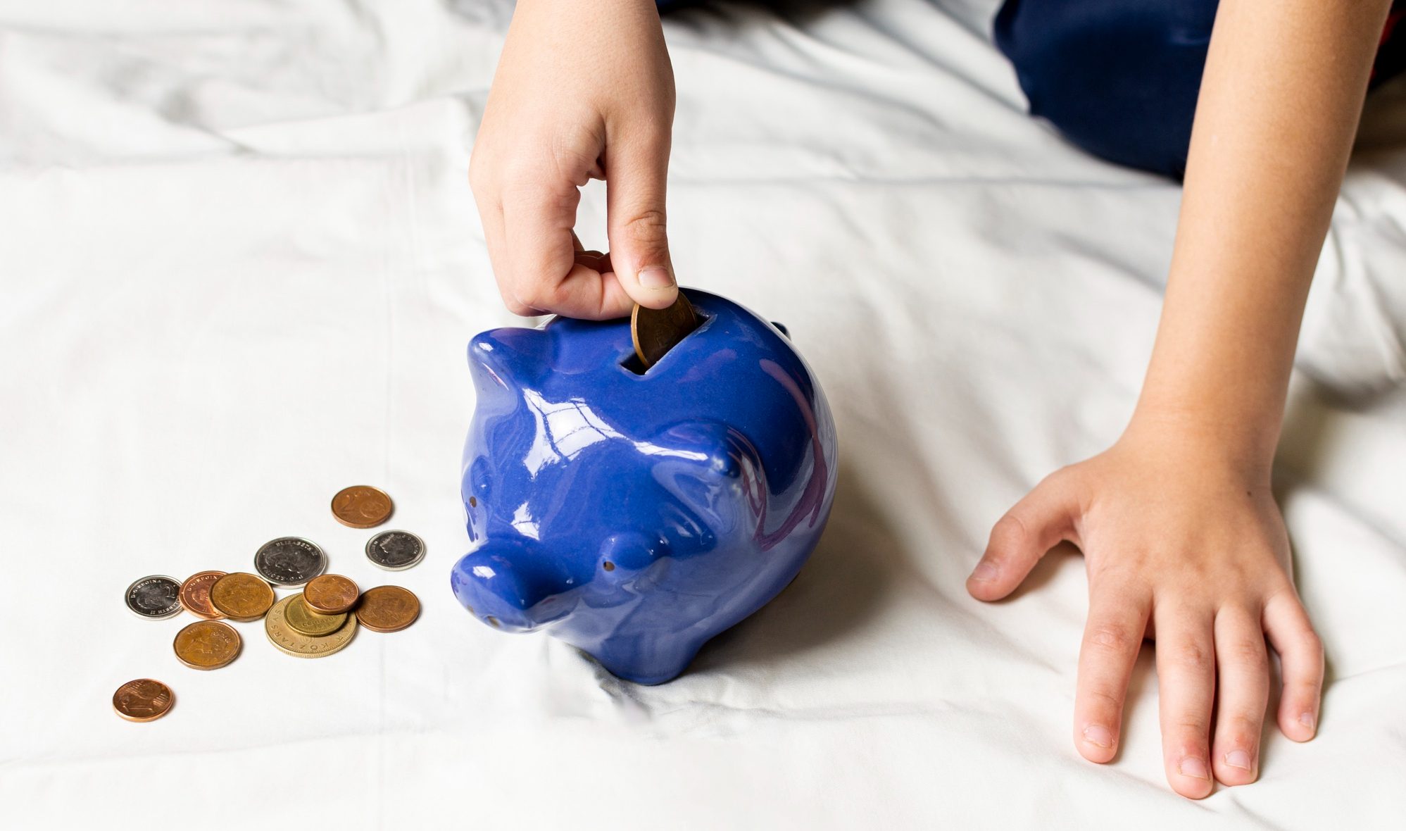 Como começar a investir em 2025 - Cofrinho azul com moedas