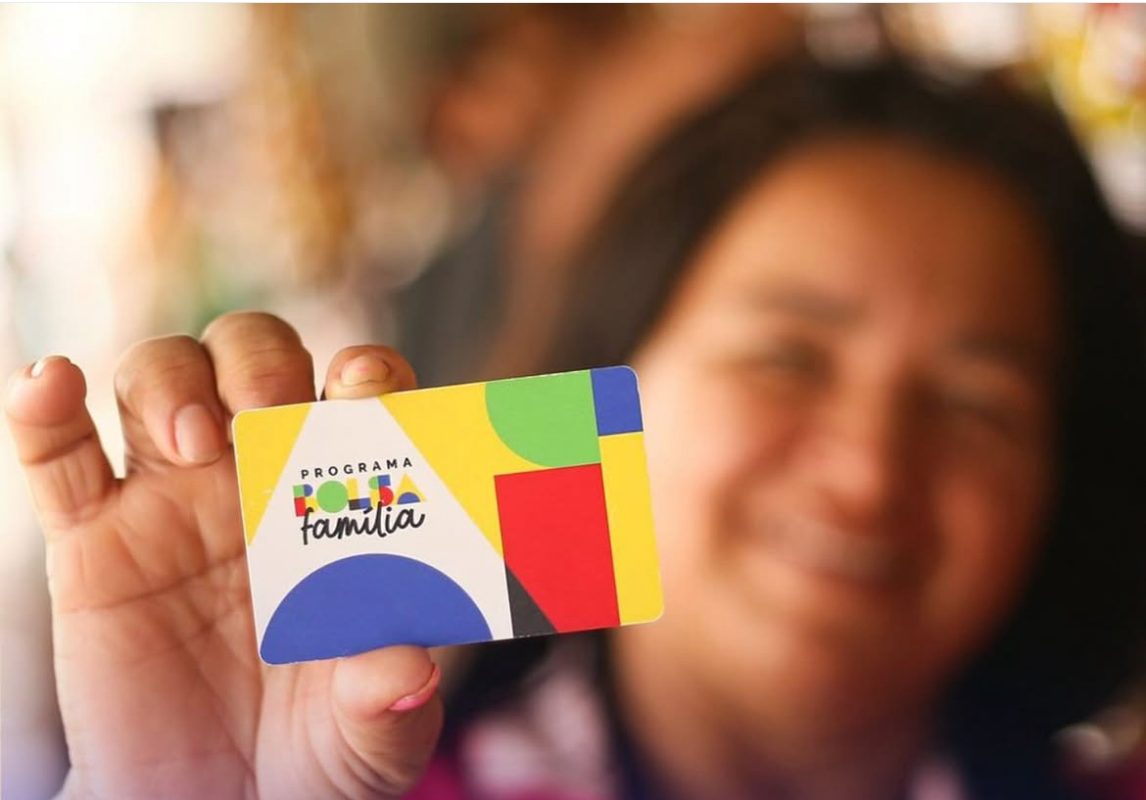 Mulher com cartão do Bolsa Família