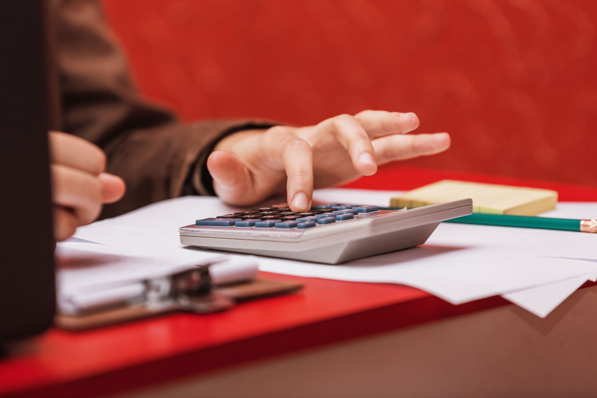 Pessoa utiliza calculadora para organizar as contas e finanças