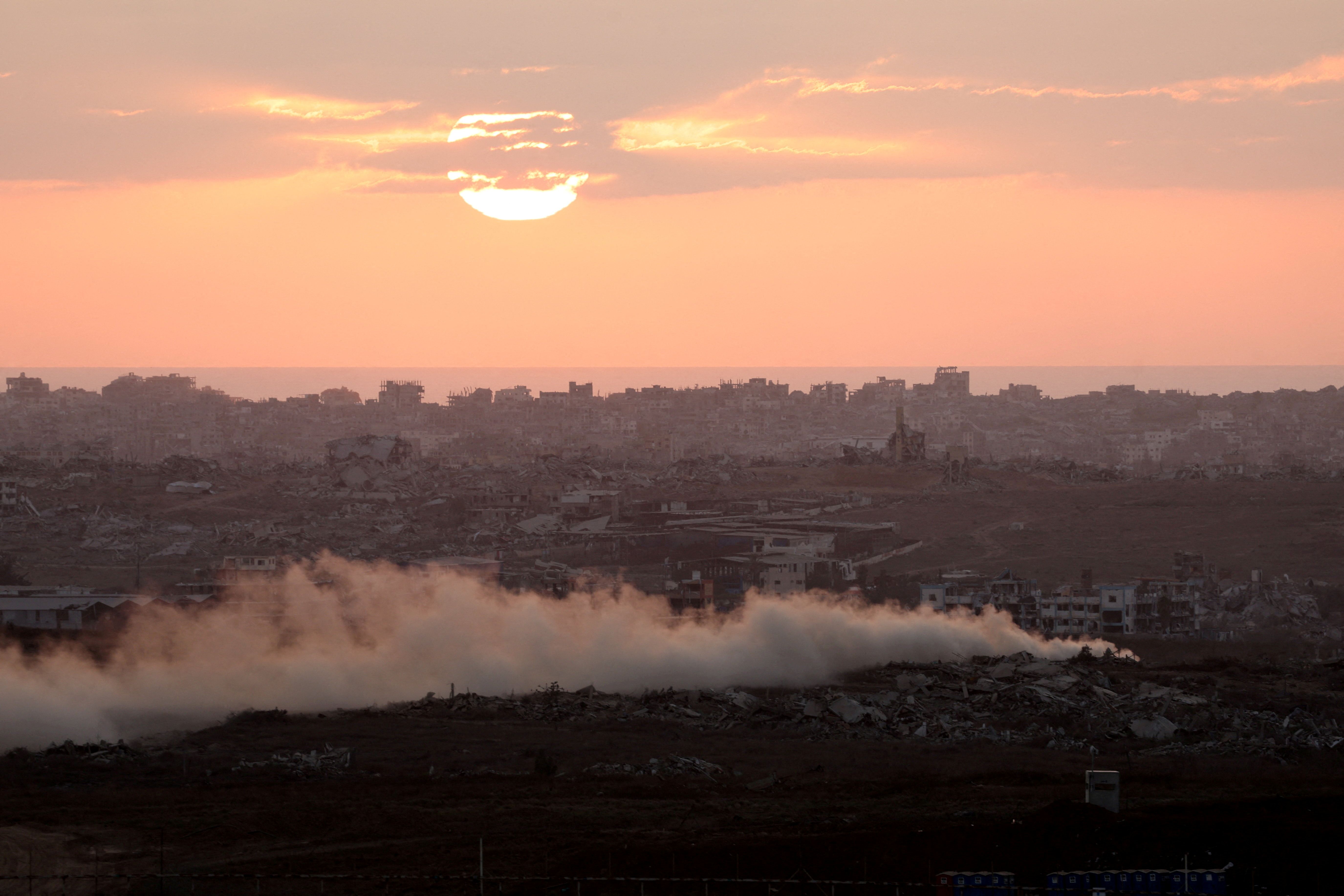 Fumaça sobe de Gaza enquanto o sol se põe, visto do lado israelense da fronteira entre Israel e Gaza REUTERS/Ronen Zvulun