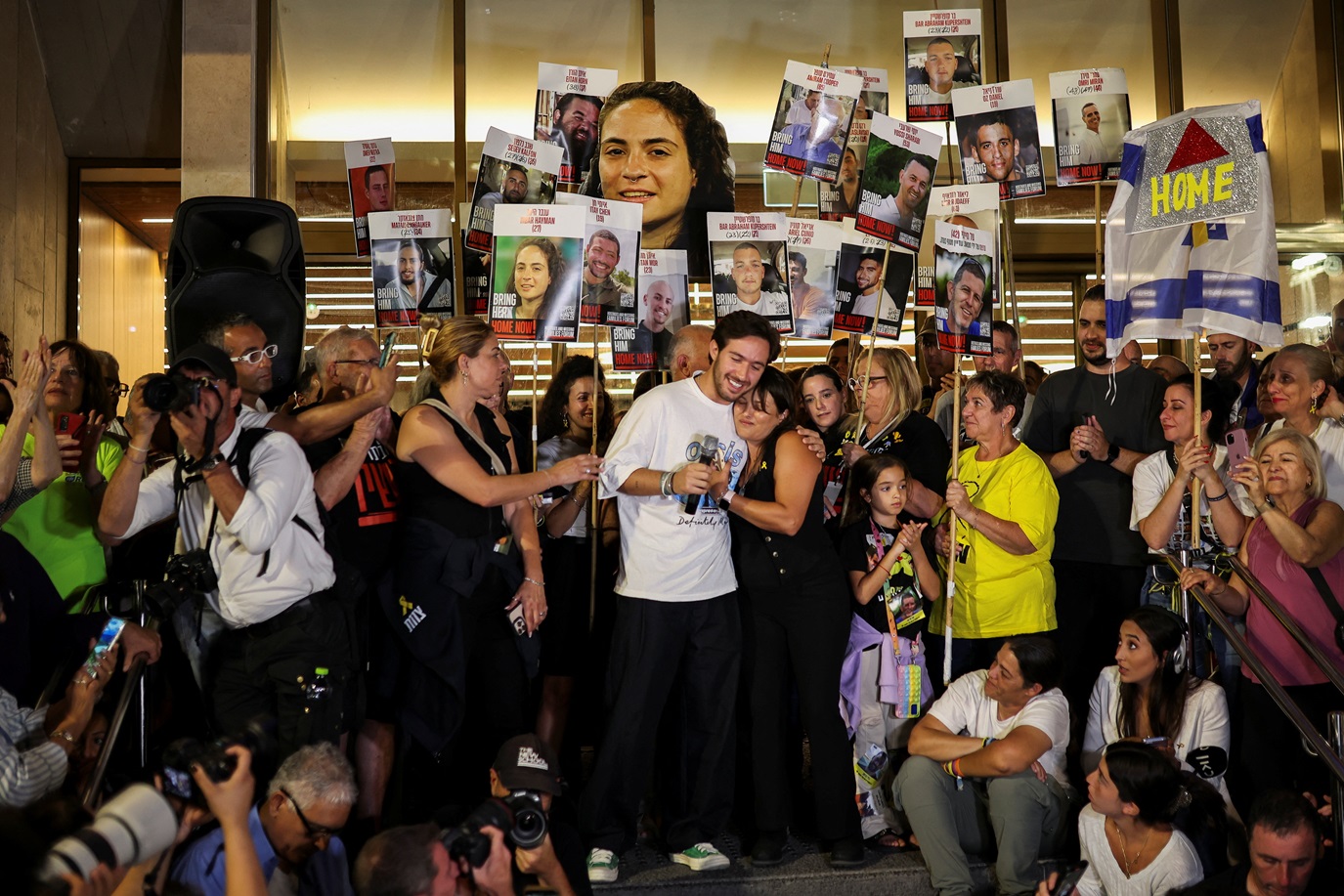 Ex-reféns Omer Shem Tov e Amit Soussana se abraçam enquanto pessoas celebram na 'Praça dos Reféns', após o presidente dos EUA, Donald Trump, anunciar que Israel e Hamas concordaram com a primeira fase de um cessar-fogo em Gaza, em Tel Aviv, Israel, 9 de outubro de 2025. REUTERS/Shir Torem