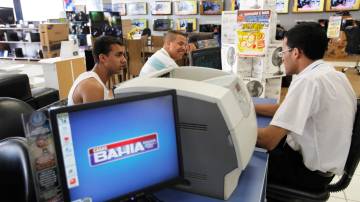 Consumidores conversam com funcionário da Casas Bahia em loja da rede em São Paulo