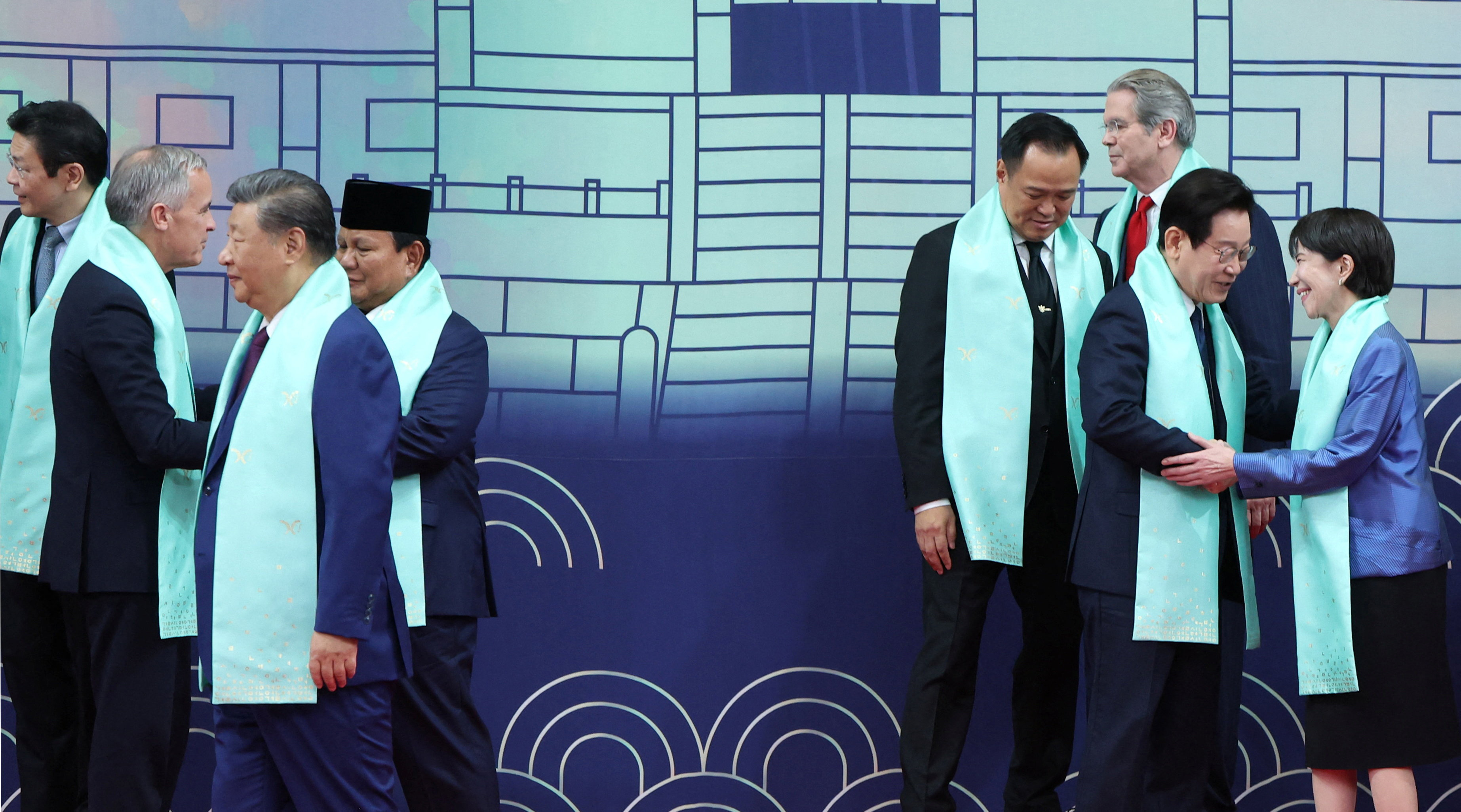 O presidente da Coreia do Sul, Lee Jae-myung, aperta a mão da primeira-ministra do Japão, Sanae Takaichi, enquanto o presidente da China, Xi Jinping, se afasta após tirar uma foto em grupo durante a cúpula da Cooperação Econômica Ásia-Pacífico (APEC) em Gyeongju, Coreia do Sul, 1º de novembro de 2025. Yonhap via REUTERS