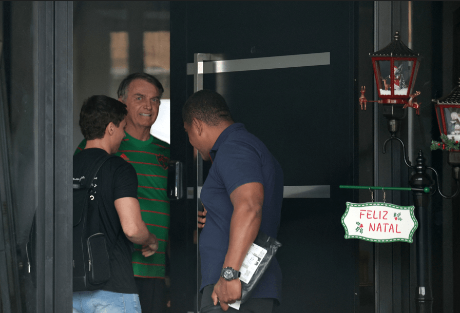 O ex-presidente do Brasil, Jair Bolsonaro, aparece na porta de sua casa, durante seu período de prisão domiciliar, em Brasília, Brasil, em 21 de novembro de 2025. REUTERS/Mateus Bonomi